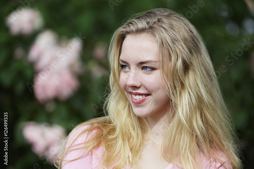 Obraz na płótnie Young woman with blonde hair looking away and smiling. w salonie