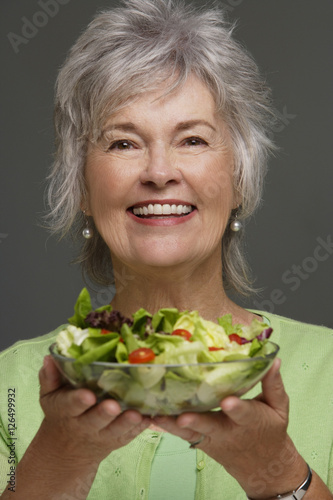 Obraz na płótnie Mature woman holding salad. w salonie