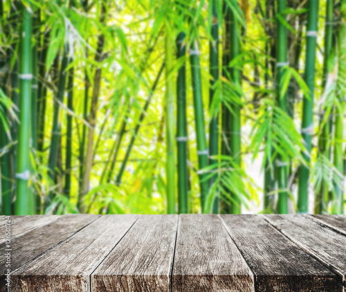 Wooden platform and Asian Bamboo forest with morning sunlight