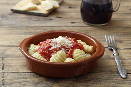 gnocchi di patate in salsa di pomodoro e formaggio sfondo tavolo rustico photo