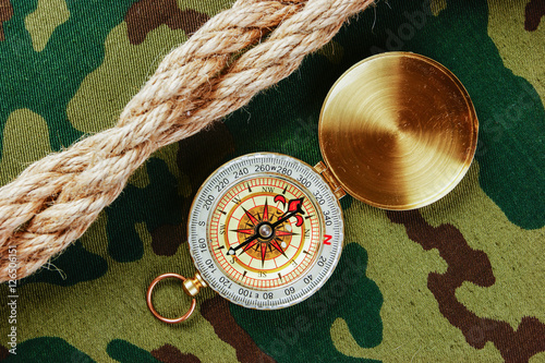 Compass and rope on a camouflage background