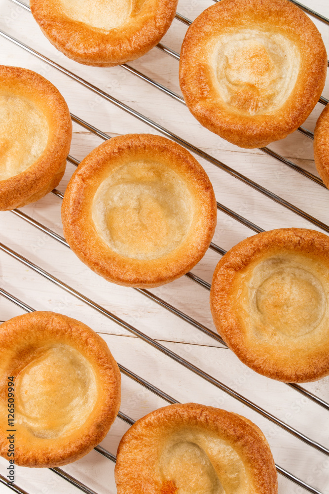 freshly baked yorkshire pudding on a cooling rack freshly baked yorkshire pudding on a cooling rack
