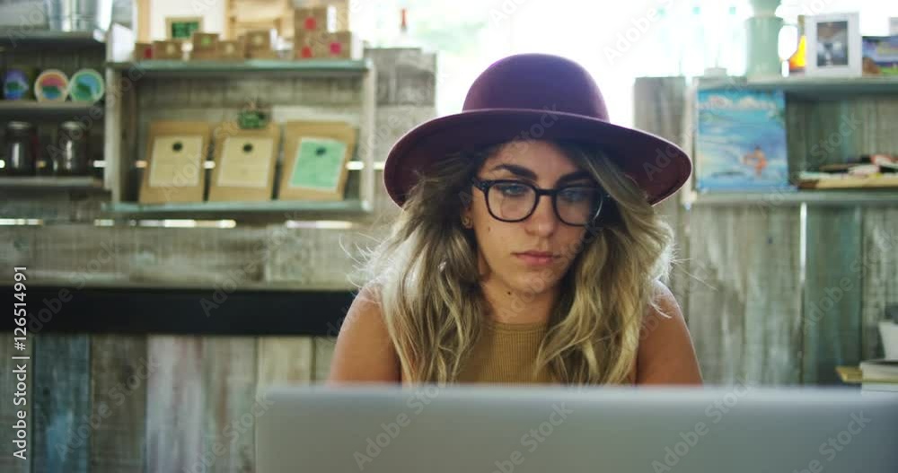 Woman using laptop computer in coffee shop, working in mobile office