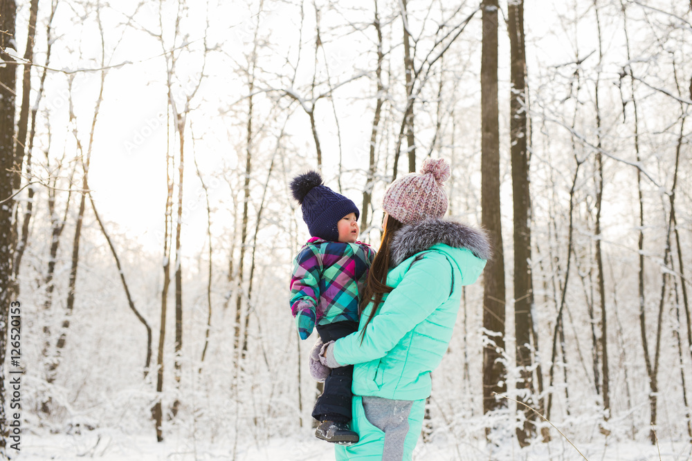 happy mother and baby in winter park. family outdoors. cheerful mommy with her child happy mother and baby in winter park. family outdoors. cheerful mommy with her child