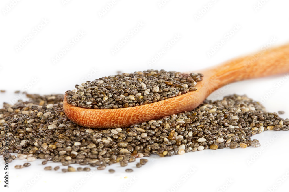 Close up chia seeds in wooden spoon on white background Close up chia seeds in wooden spoon on white background