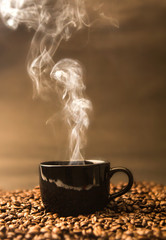 Küchenrückwand glas motiv Kaffee und Kaffeebohnen Stillleben mit einer warmen schwarzen Tasse Kaffee auf gerösteten Kaffeebohnen  © Cozine