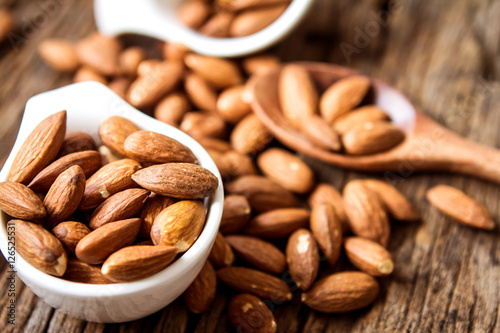 close up Peeled almonds nut in small white cup 