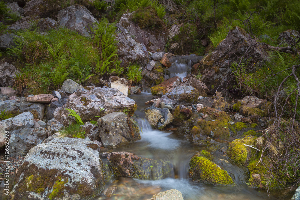 Langzeitbelichtung von kleinen Wasserfällen am Wanderweg zum Lost Valley, Glencoe, Schottland