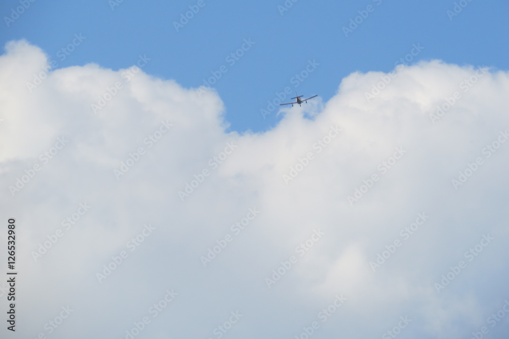 Small airplane passing in a fluffy cloud.