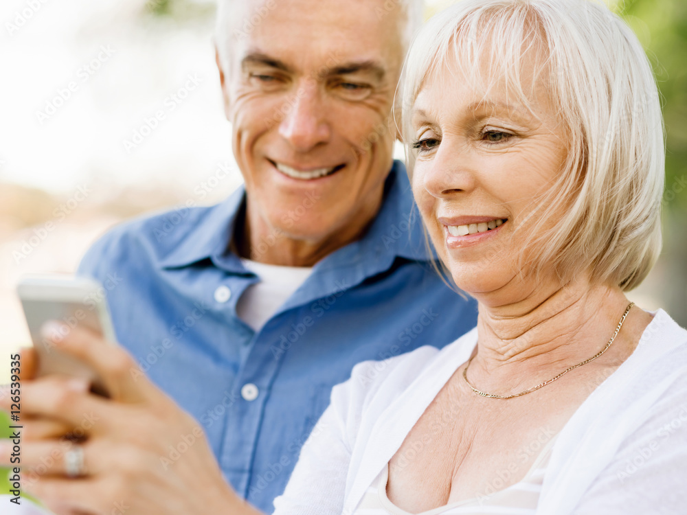 Happy senior couple looking at smartphone Happy senior couple looking at smartphone