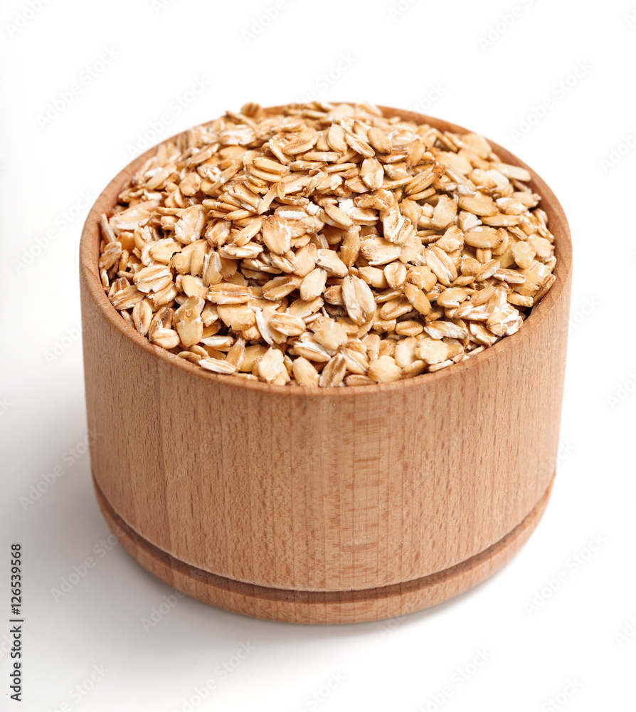 Healthy oat flakes in wooden bowl isolated on white background. Close up, high resolution product