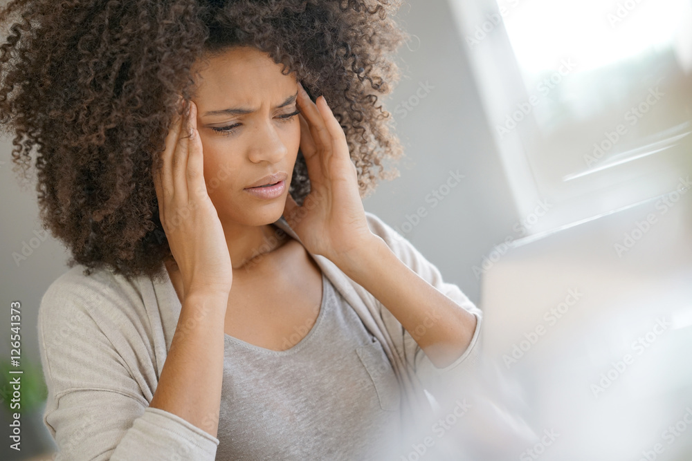 Mixed race woman having a headache working on laptop Mixed race woman having a headache working on laptop