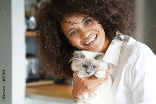 Photography Portrait of mixed race woman cuddling cat
