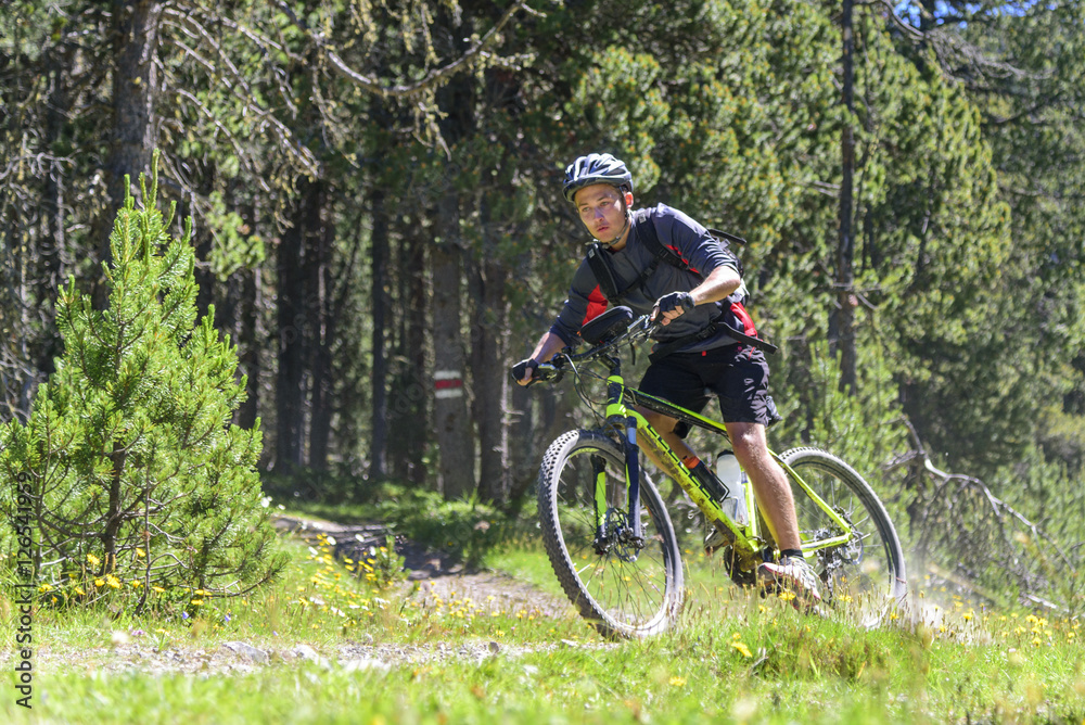 Mountainbiker driftet beim Downhill in der Kurve