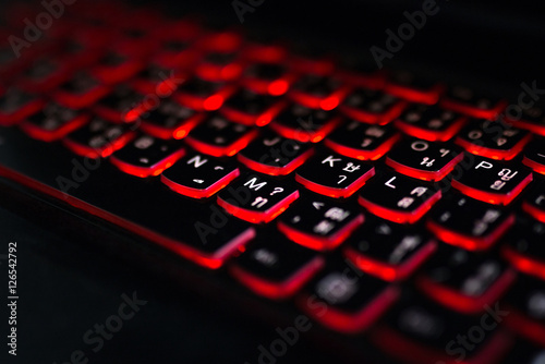 Close up. Red backlight, backlit on laptop computer or keyborad computer of gaming in the dark. Concept computer keyboard background.