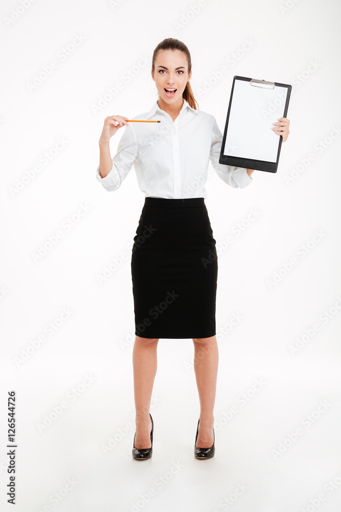Smiling young businesswoman pointing pencil at blank clipboard Smiling young businesswoman pointing pencil at blank clipboard