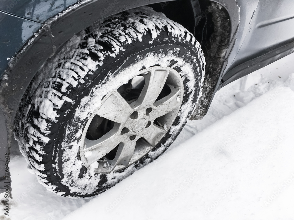 Wheel with studded tire standing in snow