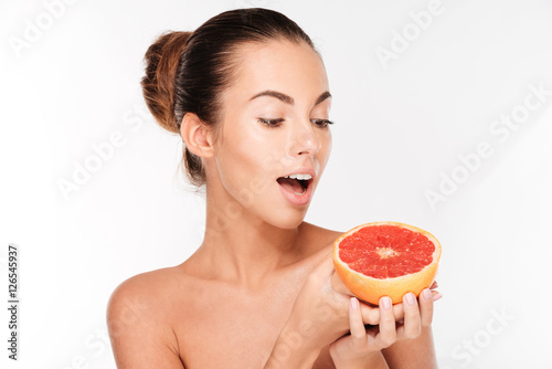 Beauty portrait of a happy woman holding grapefruit