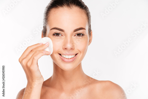 Fotografie Young beautiful cleaning face with cotton pads
