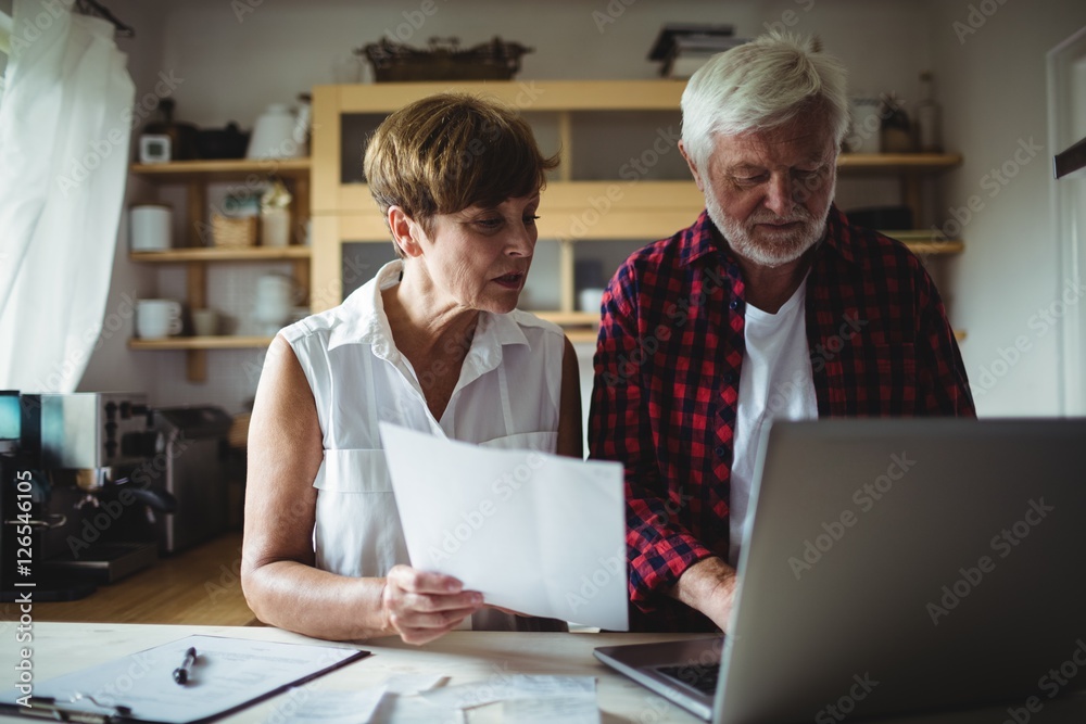 Senior couple paying bills online on laptop Senior couple paying bills online on laptop
