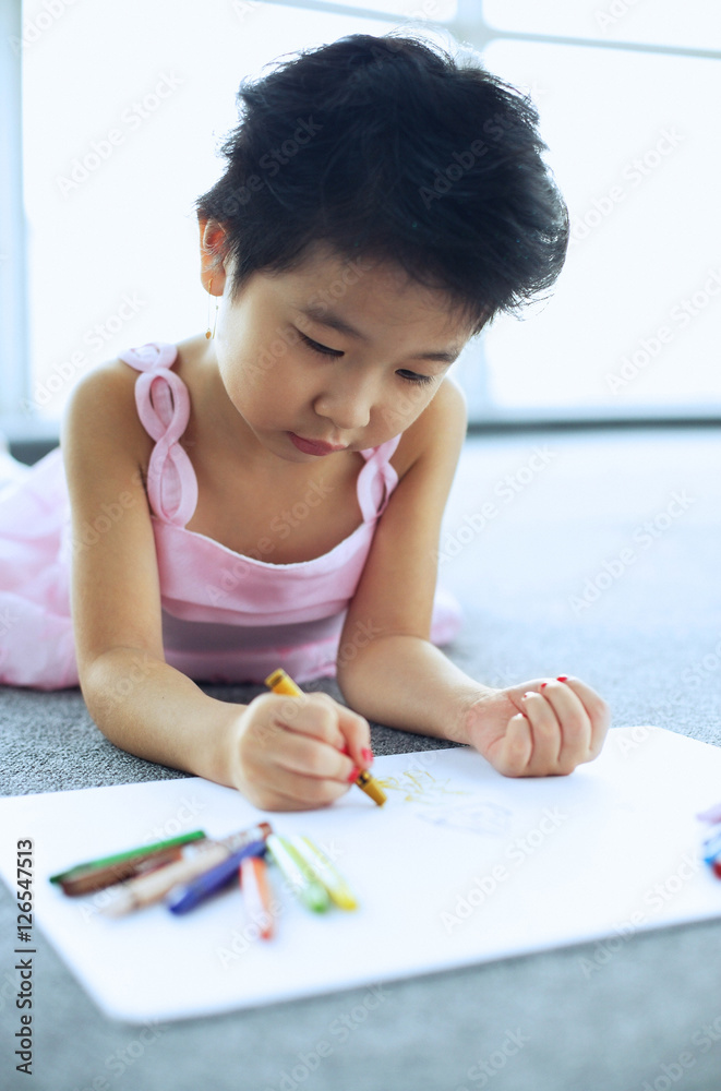 Young girl lying on floor, drawing Young girl lying on floor, drawing