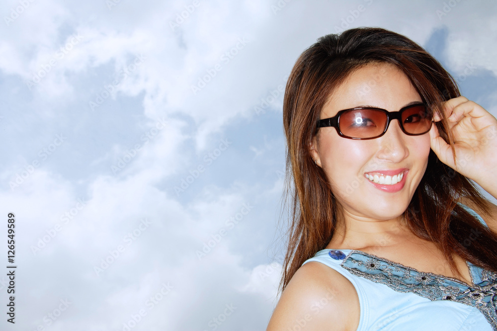 Young woman wearing sunglasses, smiling at camera Young woman wearing sunglasses, smiling at camera