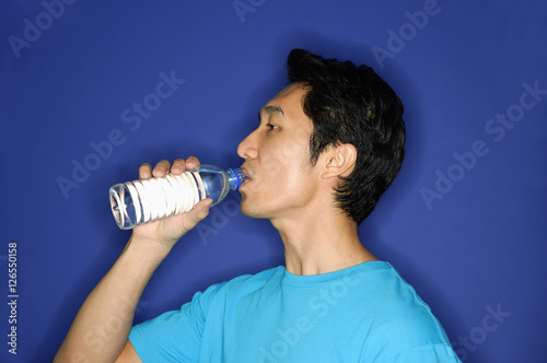 Man drinking water from disposable bottle