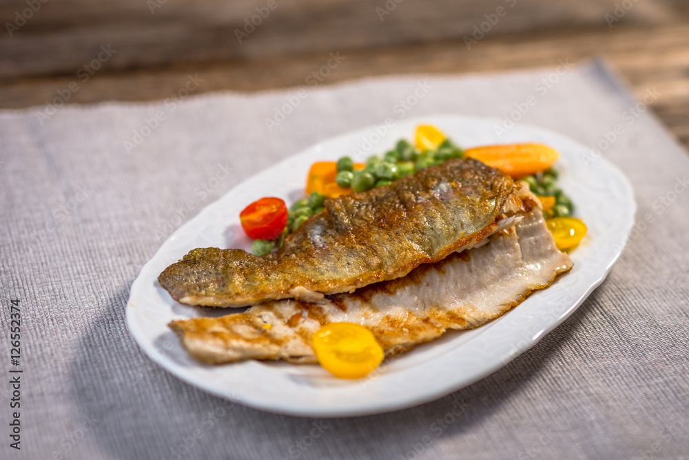 Grilled fish fillets  with   vegetables on plate