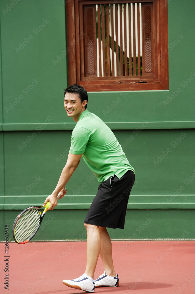Man serving a game of tennis on tennis courts