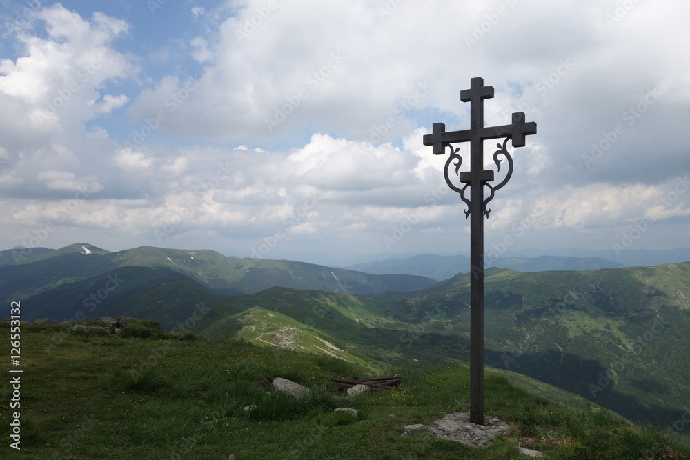 Sign of faith. Iron cross in a cloudy sky. Mount Pop Ivan, Transcarpathia