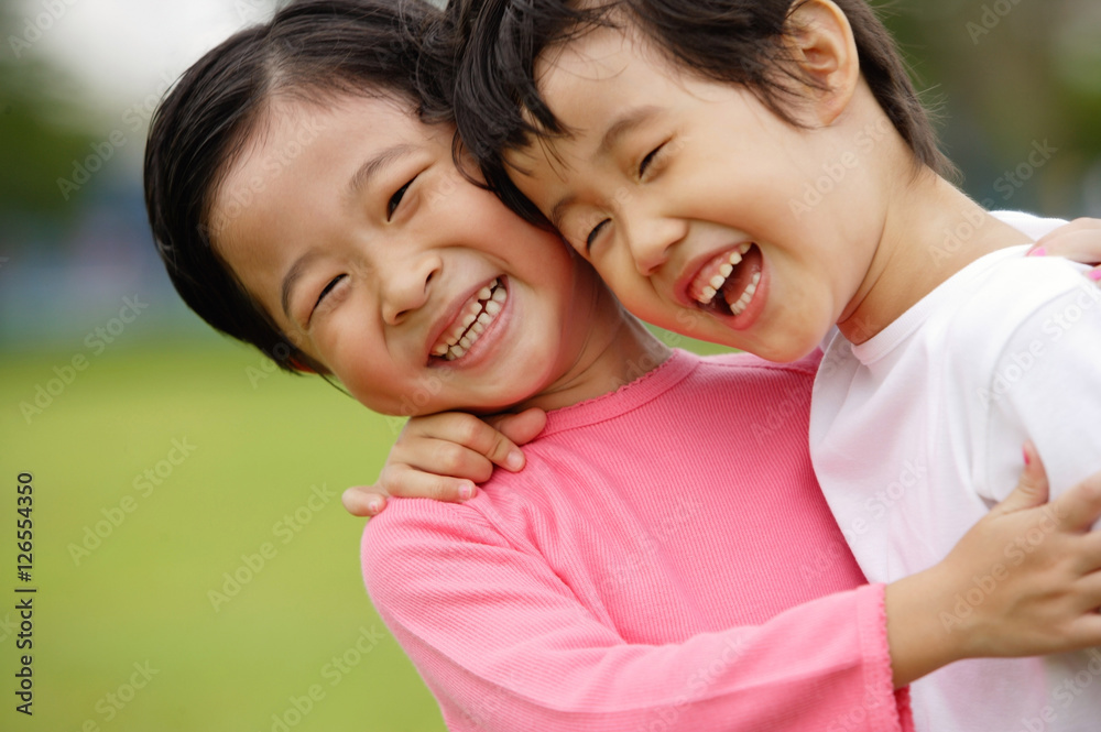 Two girls with arms around each other, laughing, portrait Two girls with arms around each other, laughing, portrait