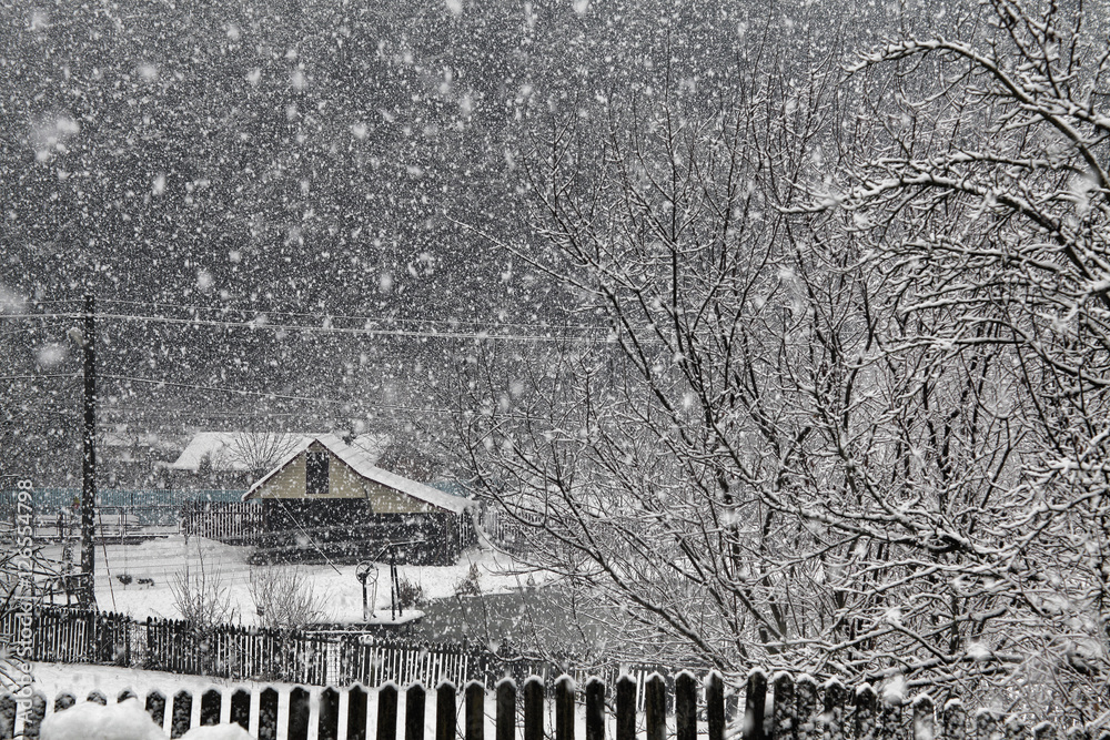 snowing in winter village, Romania
