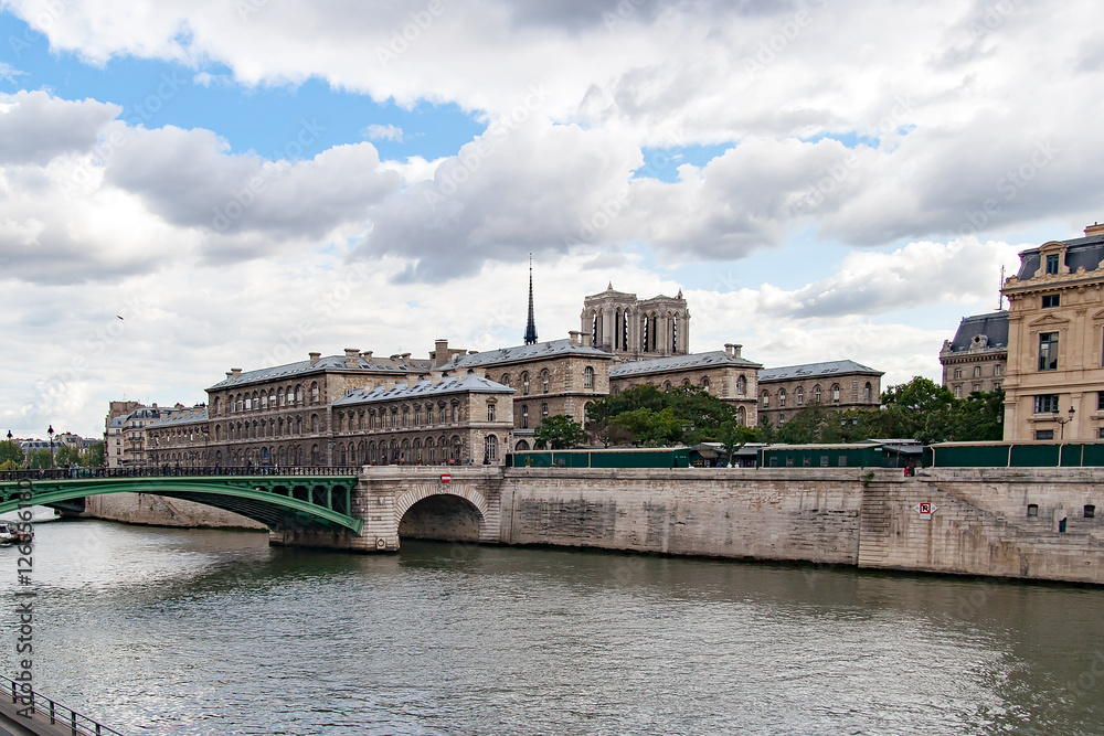 Fototapeta premium PARIS, FRANCE CIRCA APR 2016. Partial view of Notre Dame bridge, To the right the conciergerie and towers of the cathedral of Notre Dame de Paris. View from the river Seine