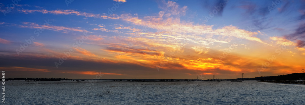 Snowy russian field during fiery sunset