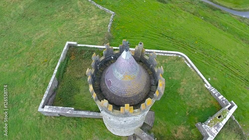 The tower castle of Ballinalacken in West Ireland it is located in the middle of the green field photo