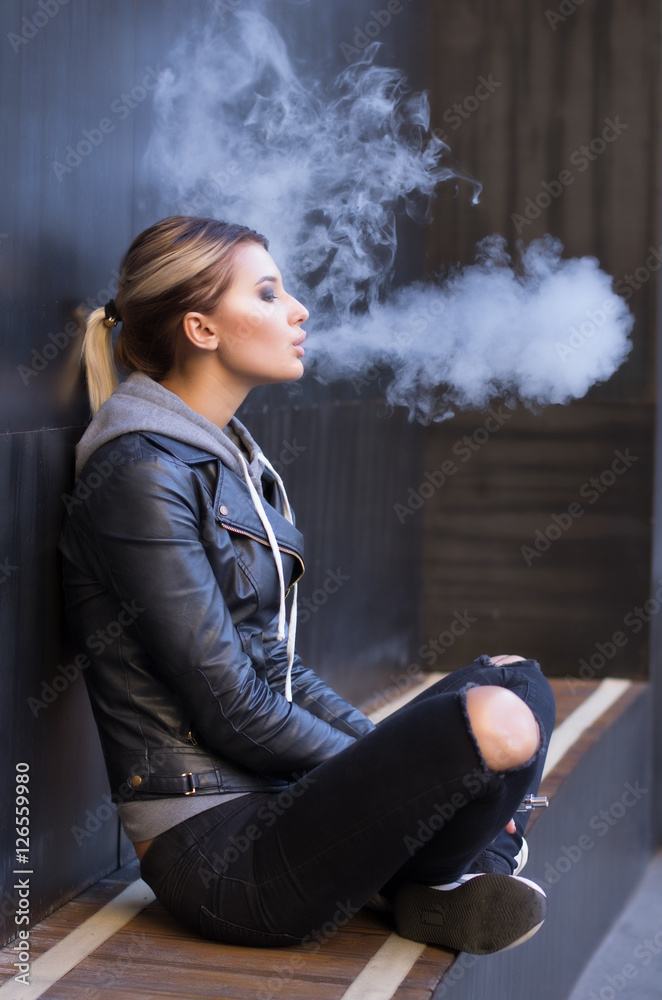 Blonde girl smoking in long latex gloves