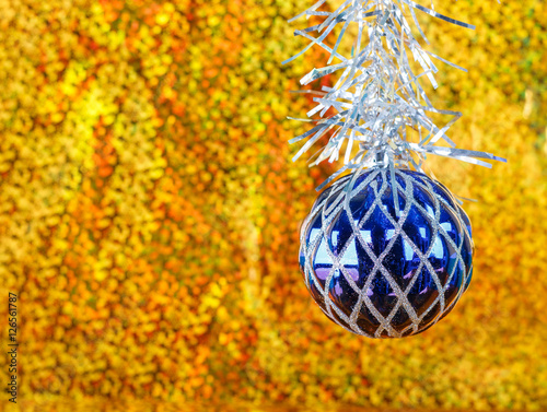 Christmas blue ball on a sparkling gold background