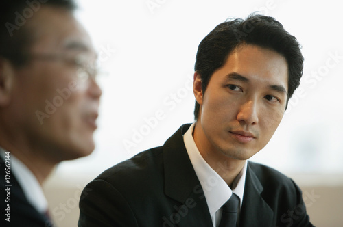 Businessman looking at person next to him