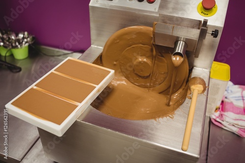 Mold filled with melted chocolate on blending machine