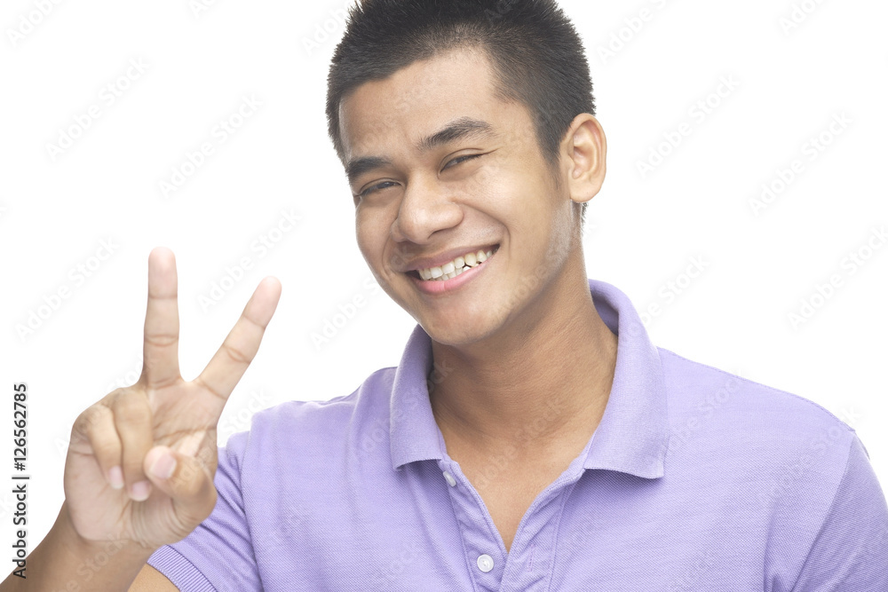 Man smiling at camera, making peace hand sign