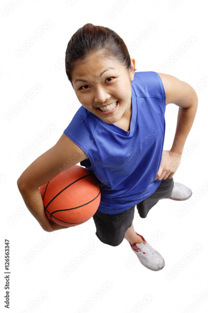 Young woman holding basketball, smiling at camera Young woman holding basketball, smiling at camera