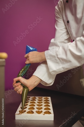 Worker filling mold with piping bag