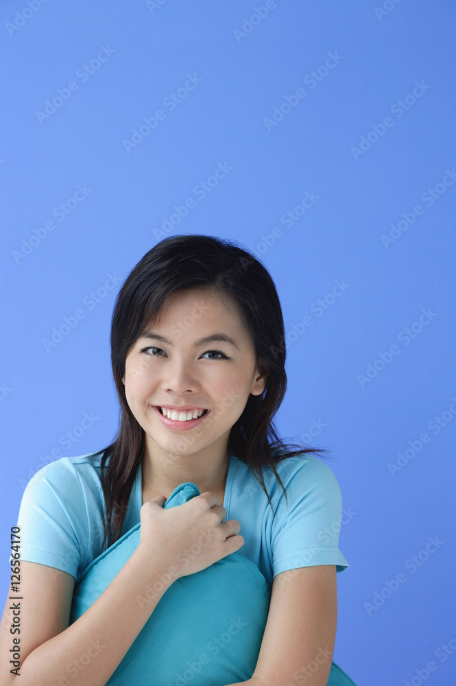 Young woman hugging pillow, looking at camera Young woman hugging pillow, looking at camera