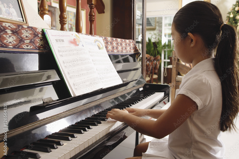Girl playing piano at home
