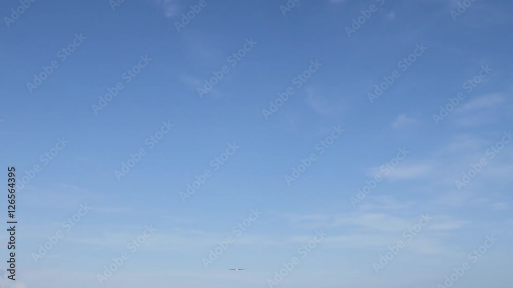 Airplane landing on island Bali airport. Cinematic shot of overhead flying aircraft on blue cloudy sky background. Enjoying happy summer vacation concept. Focal length 28mm Airplane landing on island Bali airport. Cinematic shot of overhead flying aircraft on blue cloudy sky background. Enjoying happy summer vacation concept. Focal length 28mm