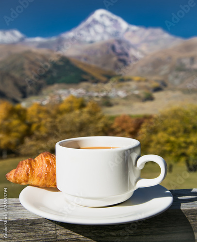 Cup of coffee and Croissant  among beautiful nature of Georgia photo