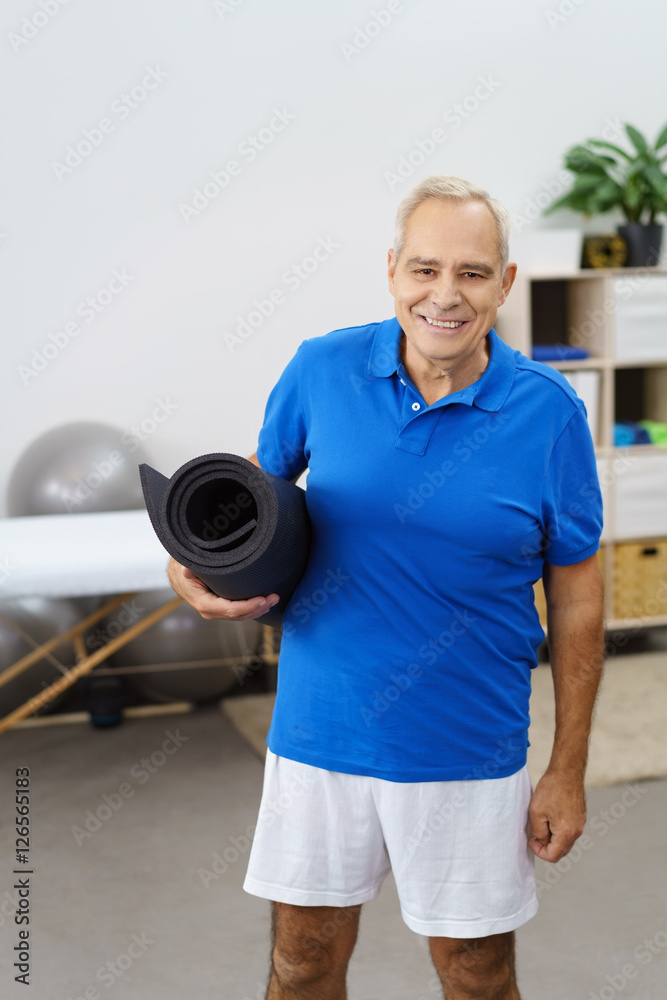 Fototapeta premium lächelnder senior mit yogamatte