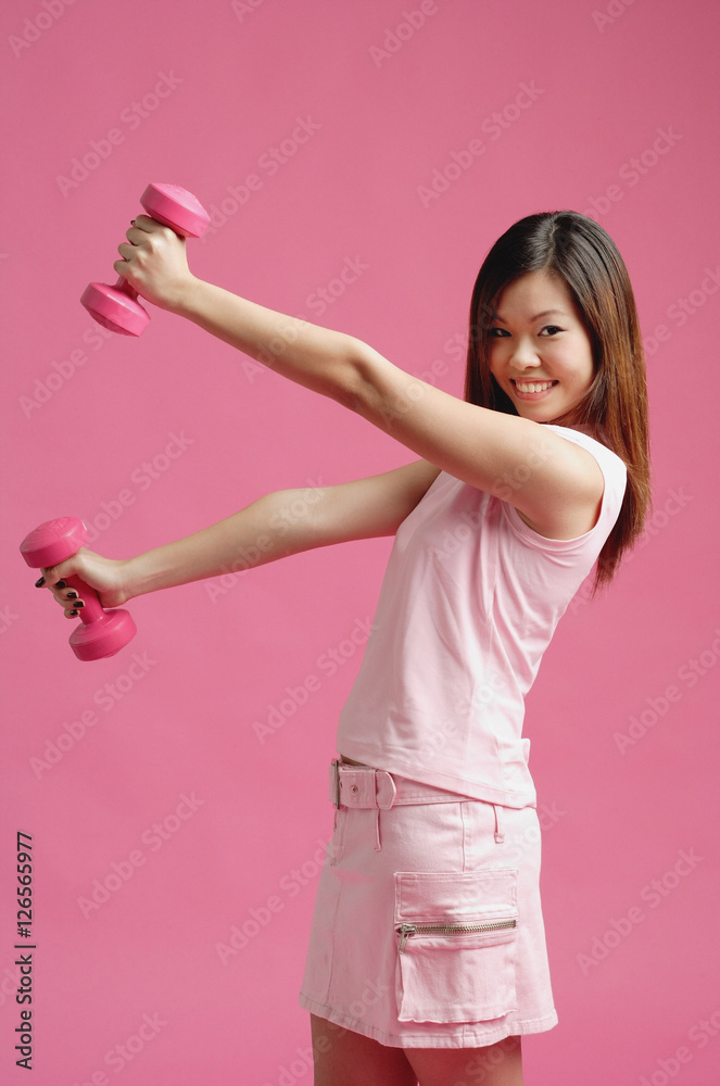 Woman dressed in pink, lifting dumbbell Woman dressed in pink, lifting dumbbell