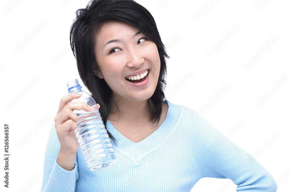 Young woman holding bottle of water, looking away Young woman holding bottle of water, looking away