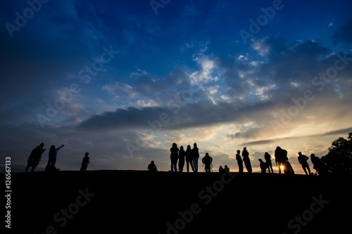 Silhouette of a group of people waiting for sun rise at the mountain peak with dramatic sky  Thailand